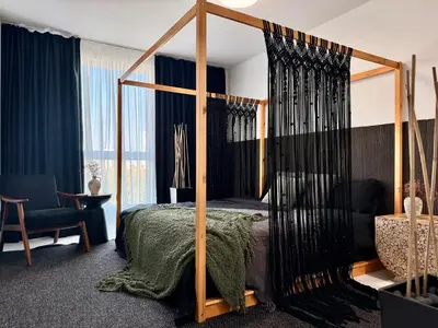 a bedroom with a canopy bed with a green blanket at Tropical Nest Residence in Hollywood