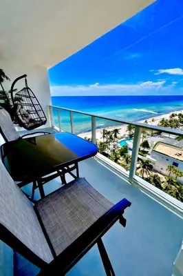 a balcony with a chair and a view of the ocean at Beach Paradise Awaits No Resort Parking Fees in Hollywood