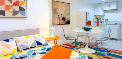 a living room with a table and a kitchen at Take It Easy - Studio Pool Waterfront in Fort Lauderdale