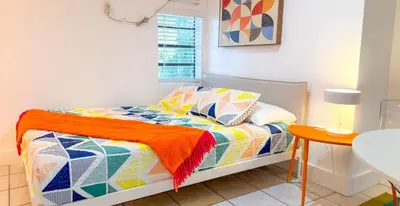 a bedroom with a bed with a colorful comforter at Take It Easy - Studio Pool Waterfront in Fort Lauderdale