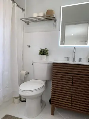 a white bathroom with a toilet and a sink at Central Fort Lauderdale 2BR Cottage Near Beach in Fort Lauderdale
