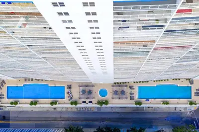 a large building with a pool in front of it at Sky-High Urban Sanctuary with Coastal Glimpses in Miami