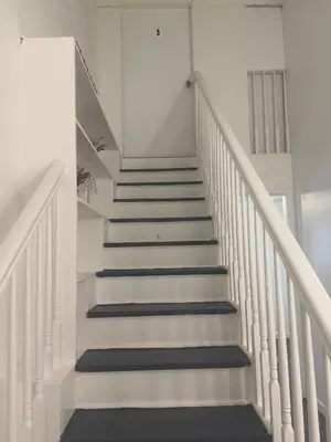 a staircase in a house with white walls and blue stairs at Ariia Fort Lauderdale Airport in Fort Lauderdale