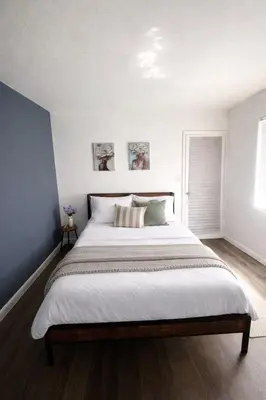 a bedroom with a large bed with white sheets at Ariia Fort Lauderdale Airport in Fort Lauderdale