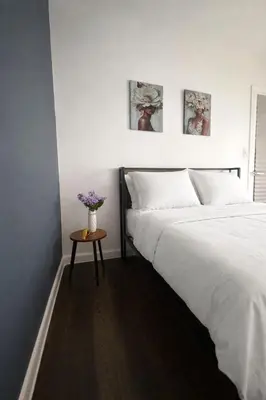a bedroom with a white bed and a table with flowers at Ariia Fort Lauderdale Airport in Fort Lauderdale