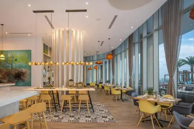 a restaurant with tables and chairs and large windows at Beachfront Luxe Condo Sunrise Oceanview Balcony in Hollywood