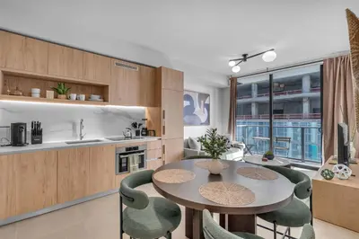 a kitchen with a table and some green chairs at Modern Chic 1BR Downtown with Rooftop Pool & Views in Miami