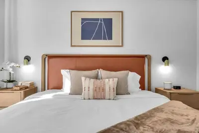 a bedroom with a white bed with a wooden headboard at Modern Chic 1BR Downtown with Rooftop Pool & Views in Miami