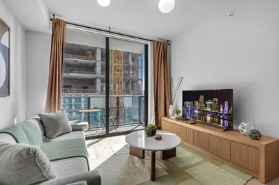 a living room with a couch and a tv at Modern Chic 1BR Downtown with Rooftop Pool & Views in Miami