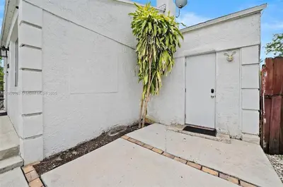 a white garage with a palm tree next to it at Studio in Design District in Miami