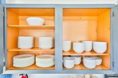 a cabinet filled with white plates and bowls at Zero Mile Villa Start your journey in Hollywood