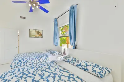 a bedroom with a bed and a ceiling fan at Zero Mile Villa Start your journey in Hollywood