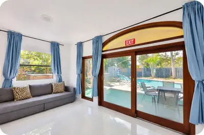 a living room with a couch and a sliding glass door at Zero Mile Villa Start your journey in Hollywood
