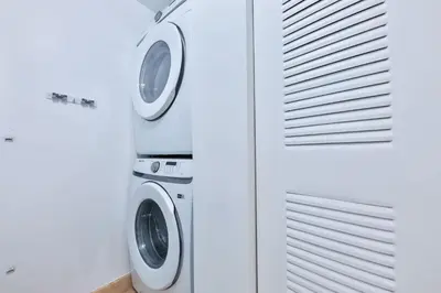 two washing machines in a white laundry room at Blue Horizon at Sunny Isles King David in Sunny Isles Beach
