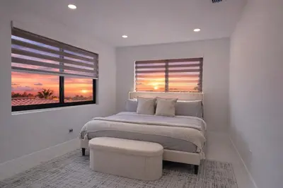 a bedroom with a bed and a window with a sunset at Luxury 1 King BR Retreat near Calle Ocho in Miami