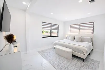 a white bedroom with a bed and a window at Luxury 1 King BR Retreat near Calle Ocho in Miami