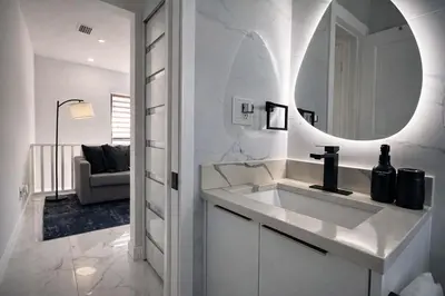 a white bathroom with a sink and a mirror at Luxury 1 King BR Retreat near Calle Ocho in Miami
