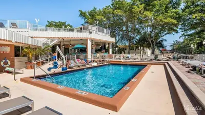 a swimming pool at a resort with lounge chairs at 2 BR-11th Floor Corner Unit - Fort Lauderdale Beach Resort in Fort Lauderdale