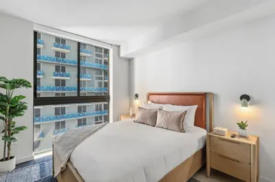 a bedroom with a bed and a large window at Central Downtown Miami Condo Featuring Rooftop Pool in Miami
