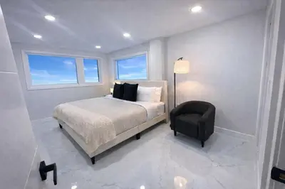 a bedroom with a bed and a chair at Luxury 2BR Miami Retreat King Suite Free Parking in Miami
