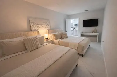 a hotel room with two beds and a television at Luxury 2BR Miami Retreat King Suite Free Parking in Miami