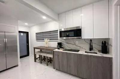 a kitchen with white cabinets and a stainless steel refrigerator at Luxury 2BR Miami Retreat King Suite Free Parking in Miami