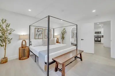 a bedroom with a large bed and a wooden table at Tropical Bliss 15 Min to Beach in Plantation