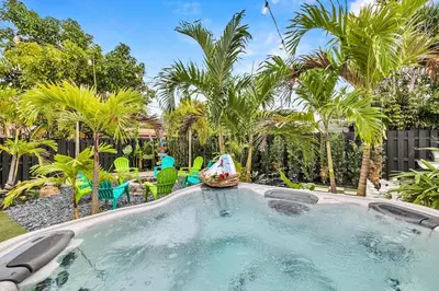 a swimming pool in a backyard with palm trees at Tropical Bliss 15 Min to Beach in Plantation