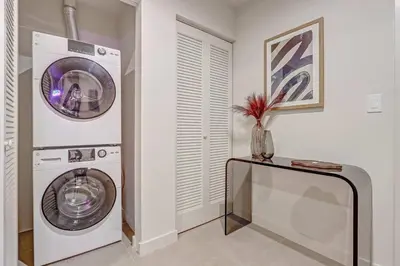 a laundry room with a washing machine and a table at MIA Worldcenter Premium 1BR Balcony & Rooftop Pool in Miami