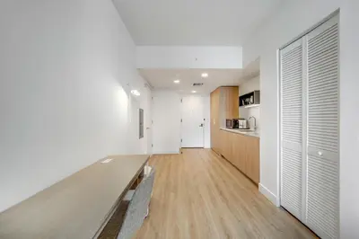 a dining room with a long table and a kitchen at Chic studio in Downtown with Gym and Pool in Miami