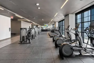 a gym with a row of treadmills and machines at Chic studio in Downtown with Gym and Pool in Miami