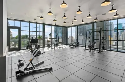 a gym with cardio equipment in a building with windows at Chic studio in Downtown with Gym and Pool in Miami