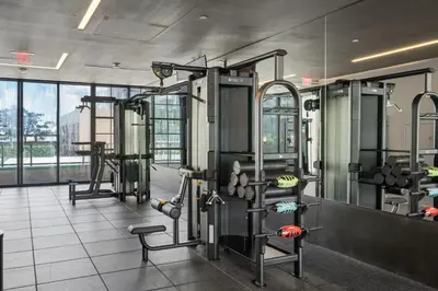 a gym with several machines and a large window at Chic studio in Downtown with Gym and Pool in Miami