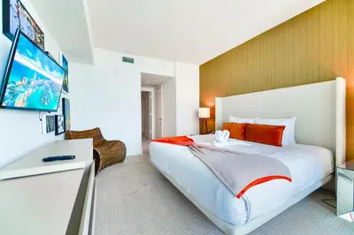 a bedroom with a large white bed with red pillows at Oceanfront Escape - Rooftop Pool & Beach Access in Hollywood
