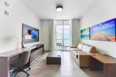 a living room with a couch and a desk at Ocean View Stay with Rooftop Pool Near the Beach in Hollywood
