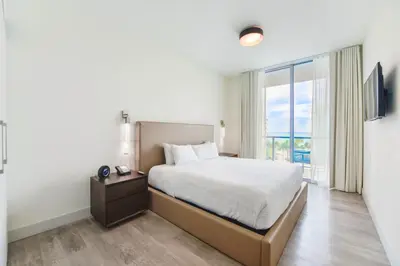 a bedroom with a bed and a large window at Ocean View Stay with Rooftop Pool Near the Beach in Hollywood