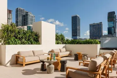 a patio with couches and tables and a city skyline at Sky Corner Residence- Pool Parking Amenities in Miami