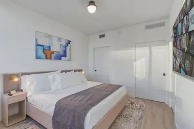 a white bedroom with a bed and a glass door at Miami Skyline 1BR Sleeps 4 with Elite Amenities in Miami