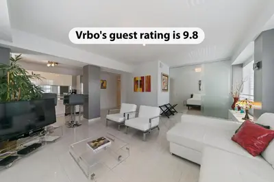 a living room with a white couch and a tv at South Beach, Perfect Oceanfront Apartment, Iconic Art Deco Building, Walk to Everything! in Miami Beach