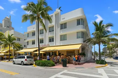 a large white building with palm trees in front of it at South Beach, Perfect Oceanfront Apartment, Iconic Art Deco Building, Walk to Everything! in Miami Beach