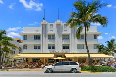 a car parked in front of a building with a palm tree at South Beach, Perfect Oceanfront Apartment, Iconic Art Deco Building, Walk to Everything! in Miami Beach