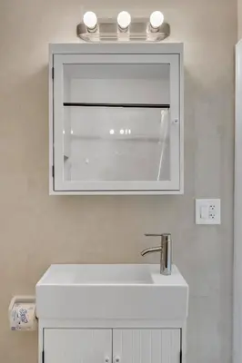 a bathroom with a white sink and a mirror at Spacious & Stylish 2BR Retreat near Victoria Park in Fort Lauderdale