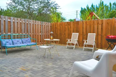 a patio with chairs and a blue couch and a table at Spacious Entire Duplex for Family Stay in Miami