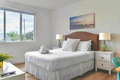 a bedroom with a large white bed with two lamps at Spacious Entire Duplex for Family Stay in Miami