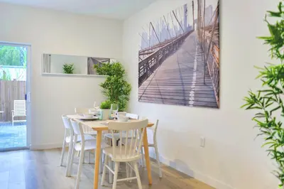 a dining room with a table with chairs and a painting on the wall at Spacious Entire Duplex for Family Stay in Miami