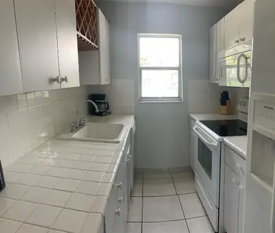 a white kitchen with a sink and a window at Le Cartier 207 STR-02440 in Sunny Isles Beach