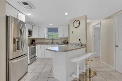 a kitchen with white cabinets and a clock on the wall at Le Frontenac 210 STR-01055 in Sunny Isles Beach
