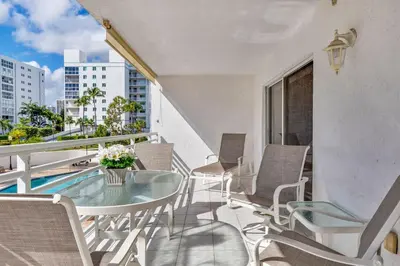 an apartment balcony with a glass table and chairs at Le Frontenac 210 STR-01055 in Sunny Isles Beach