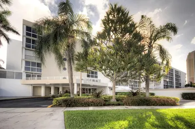a building with palm trees in front of it at Le Frontenac 210 STR-01055 in Sunny Isles Beach