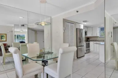 a dining room and kitchen with a glass table and chairs at Le Frontenac 210 STR-01055 in Sunny Isles Beach
